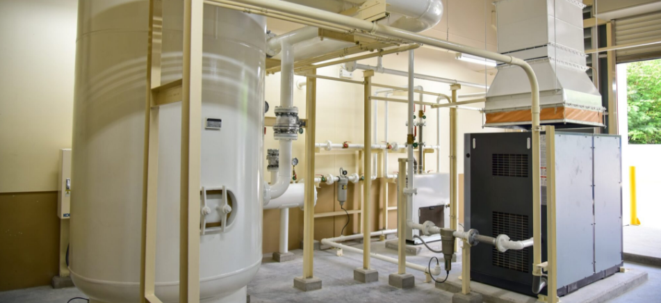 Industrial compressor room with piping and ventilation